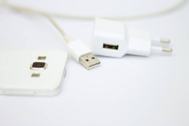 Beyaz telefon ve telefon kablosu beyaz düzlükte izole edilmiş.