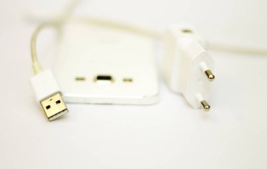 Beyaz telefon ve telefon kablosu beyaz düzlükte izole edilmiş.
