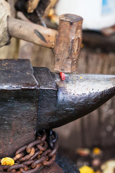 Blacksmith forges rod with sledgehammer on anvil — Stock Photo, Image