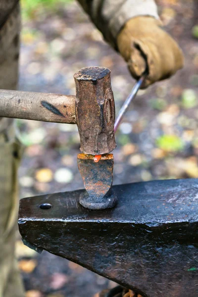 Blacksmith chops rod with sledgehammer and chisel — Stock Photo, Image