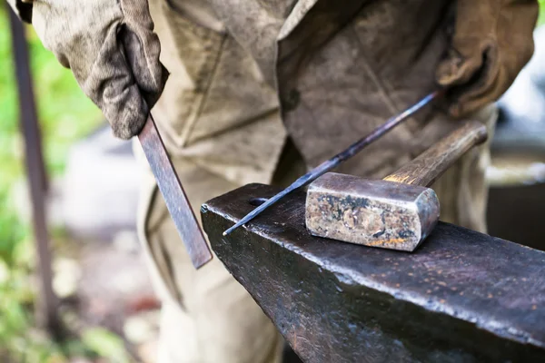 Blacksmith processing steel rod by file on anvil — Stock Photo, Image