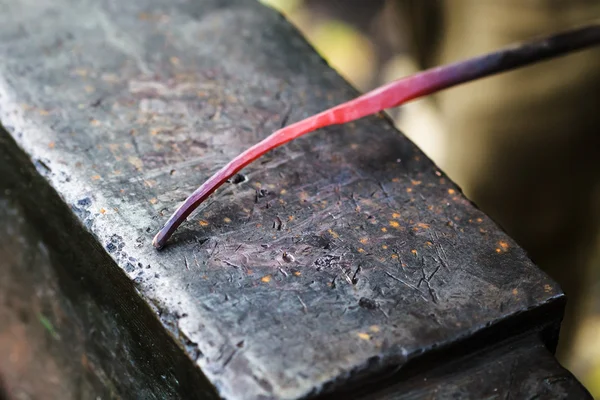 Red hot glowing steel rod on anvil close up — Stock Photo, Image