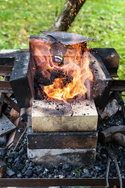 Iron rod is heated in brick forging furnace — Stock Photo, Image
