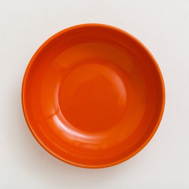 above view of orange bowl on plastering plate clipart