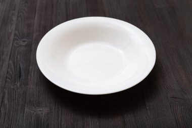 koyu kahverengi tahta üzerinde beyaz derin plaka