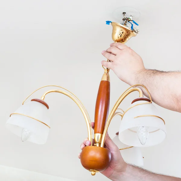 Electrician removes decorative ceiling chandelier — Φωτογραφία Αρχείου