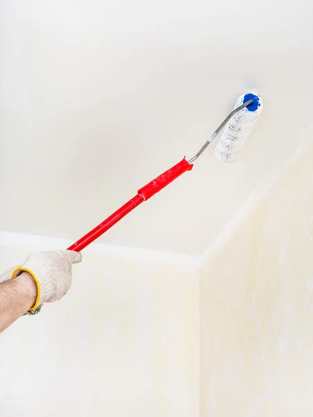 Werknemer schildert het plafond met witte verf — Stockfoto