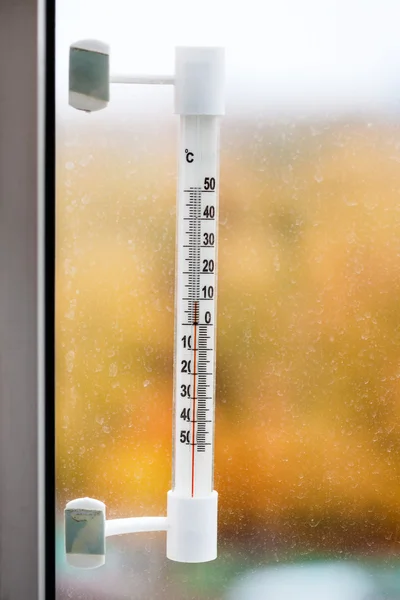 Outdoor thermometer on home window pane in autum — ストック写真