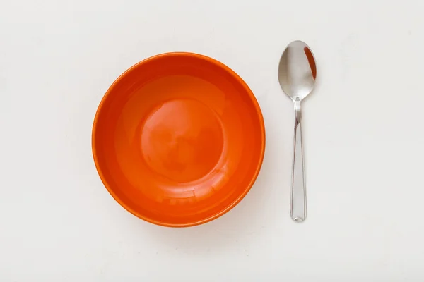 Vista superior de tigela de laranja e colher em gesso branco — Fotografia de Stock