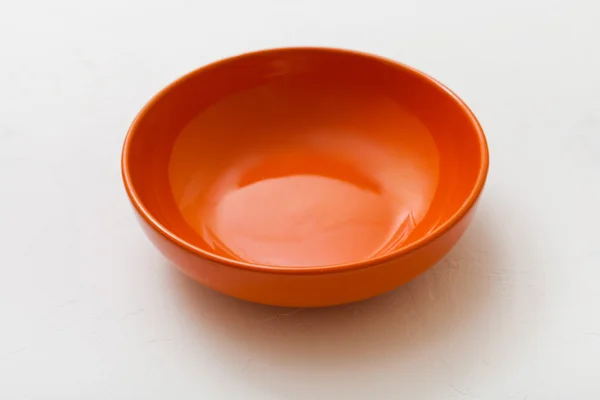 Un tazón naranja sobre yeso blanco — Foto de Stock