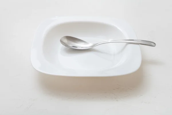 Tazón blanco cuadrado con cuchara en yeso — Foto de Stock