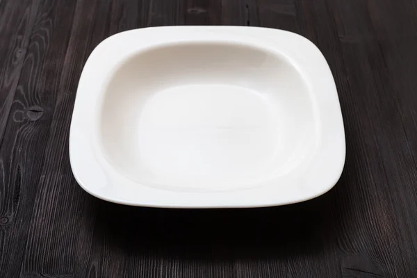 White bowl on dark brown board — ストック写真