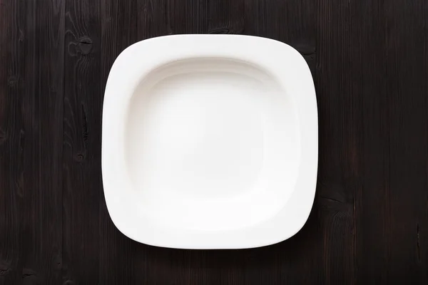 Top view of white bowl on dark brown table — ストック写真