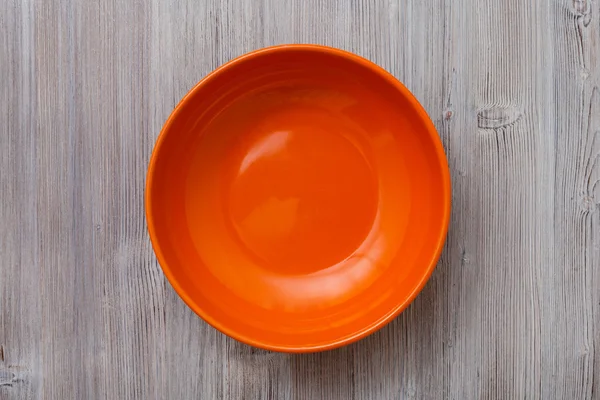 Above view of orange bowl on gray brown table — Stock Photo, Image