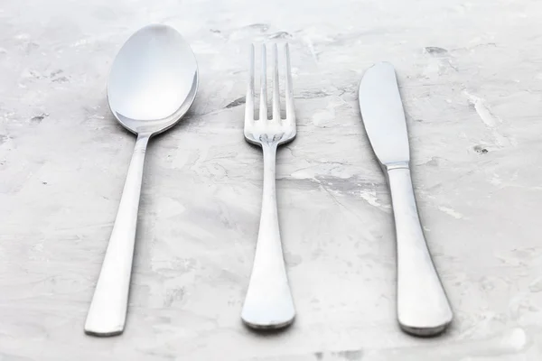 Serving set from knife, fork, spoon on concrete — Stock Photo, Image