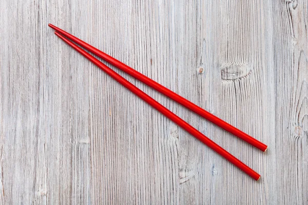 Palillos rojos de madera sobre tabla de madera marrón claro — Foto de Stock