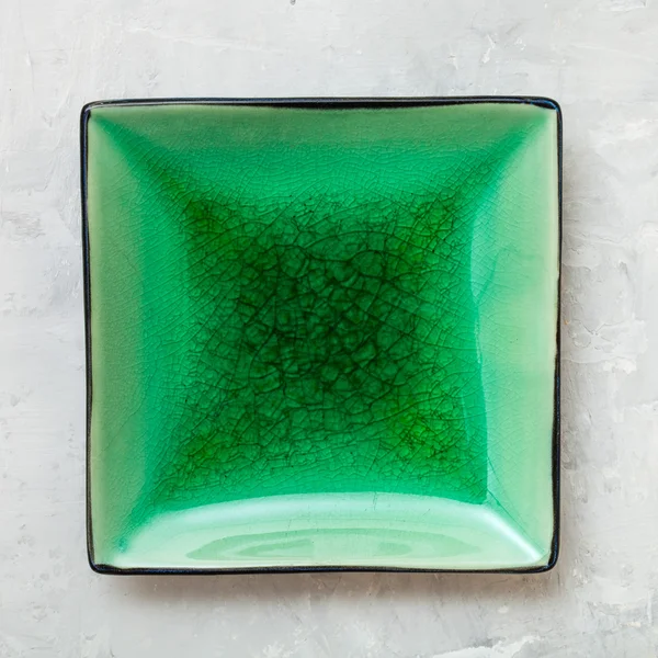 Top view of green square saucer on gray concrete — ストック写真