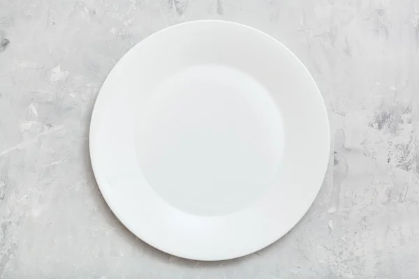 Above view of white plate on gray concrete surface — Φωτογραφία Αρχείου