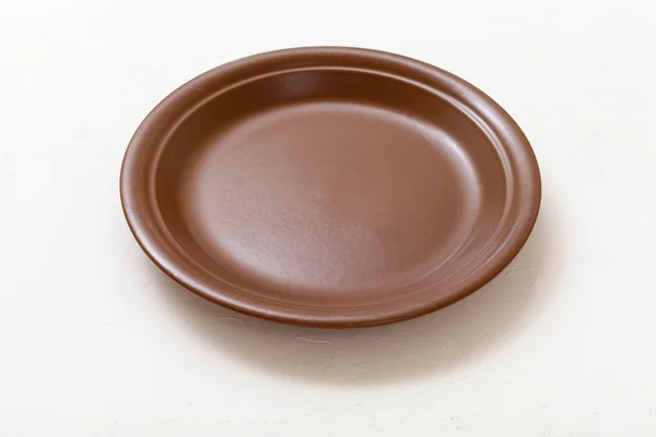 Brown plate on white plastering board — Stockfoto