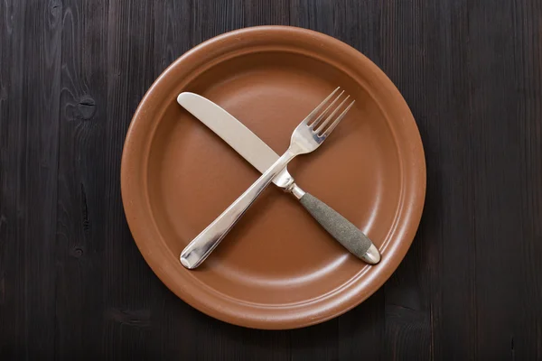 Draufsicht auf braunen Teller mit Kultivierung auf dunklem Tisch — Stockfoto