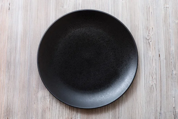 Top view of black plate on gray brown table — Stock Photo, Image