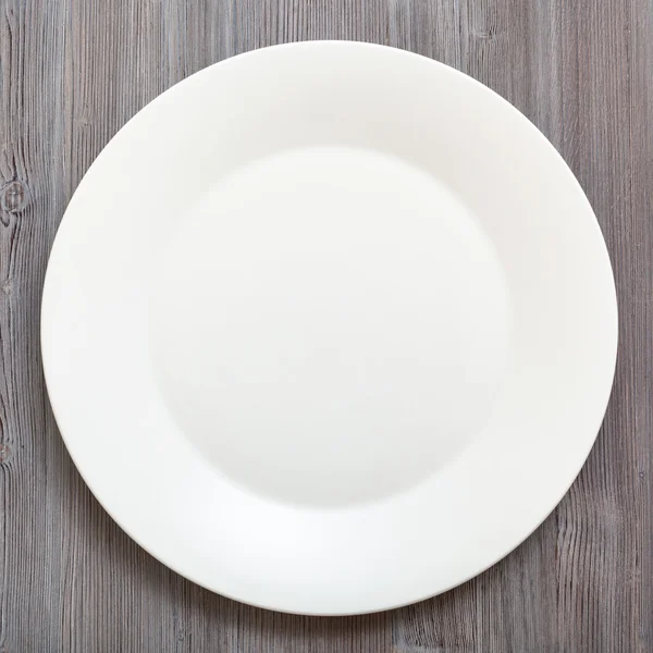 Top view of white plate on gray brown table — Φωτογραφία Αρχείου