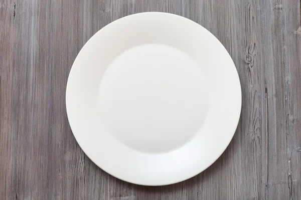 Above view of white plate on gray brown table — Φωτογραφία Αρχείου
