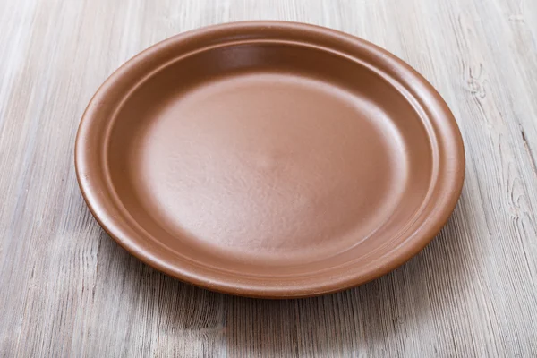 Brown plate on gray brown table — Stockfoto