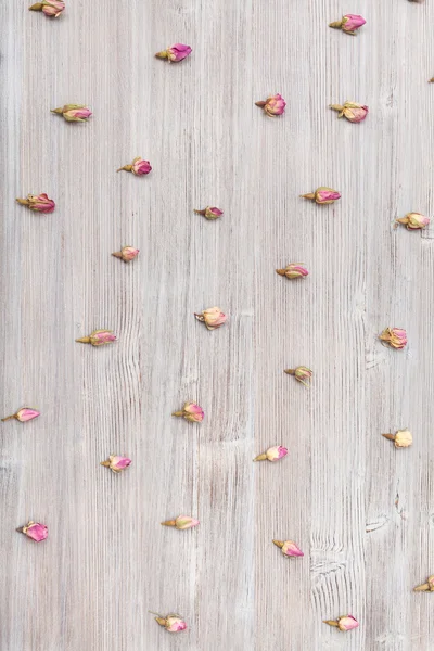 Розовые бутоны на деревянной поверхности — стоковое фото