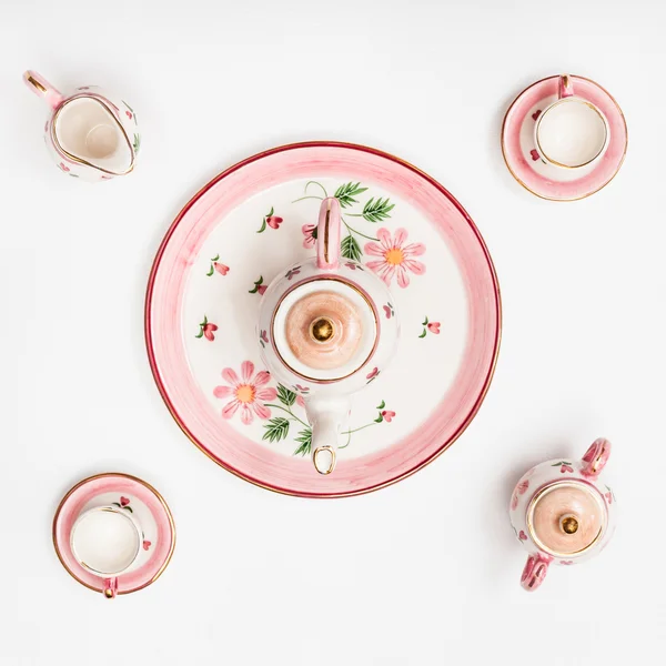 Fehér papír alapon rózsaszín porcelán Teáskészlet — Stock Fotó