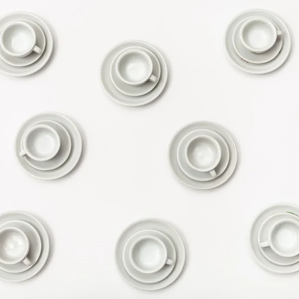 Top view several white cups and saucers on white — Stock Photo, Image