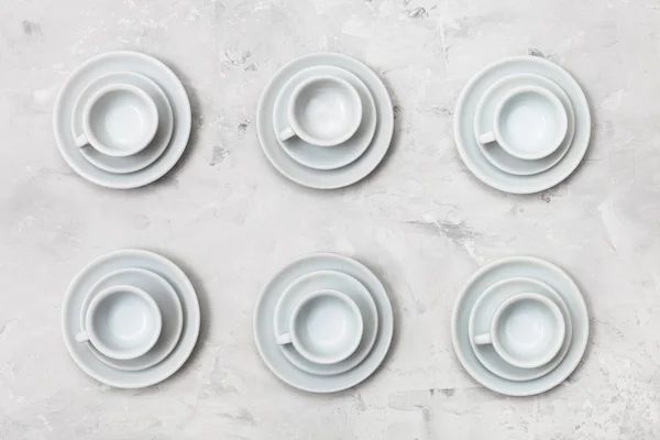 Top view of six white cups and saucers on concrete — Stock Photo, Image