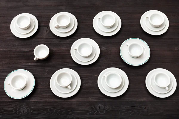 Above view of cups and saucers on dark brown board — Stock Photo, Image