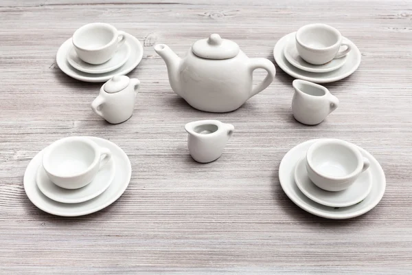 Cups with saucers and tea set on gray brown table — Stock Photo, Image