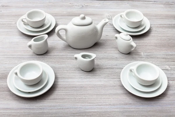 Cups with saucers and tea set on gray brown board — Stock Photo, Image