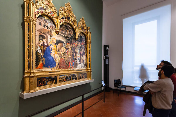 Visitors view painting in room of Uffizi Gallery