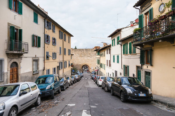 FLORENCE, ITALY - NOVEMBER 7, 2016: Via del Monte alle Croci and gate Porta San Miniato in city wall in Florence. Gate is part of ancient fortress wall in Oltrarno district, it was built in 1320.