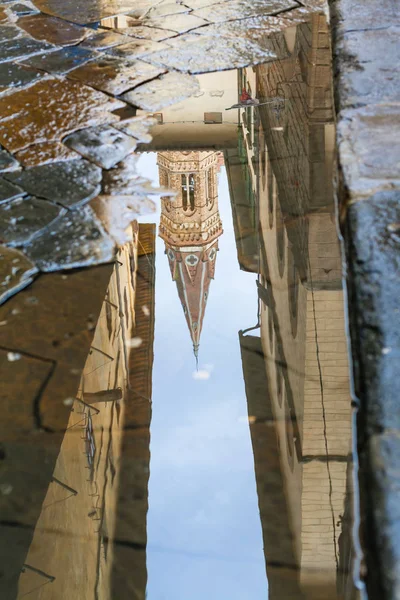 Tower of church reflected in puddle — Stock Photo, Image