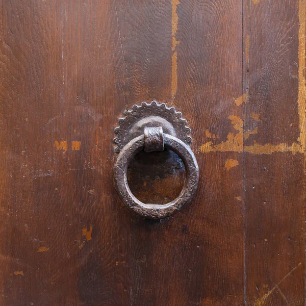 Ancient bronze round knocker on old brown door — Stock Photo, Image