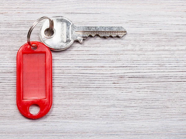 键和木制背景上的红色钥匙链 — 图库照片