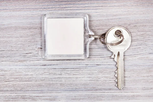 Key with key chain on wooden board — Stock Photo, Image