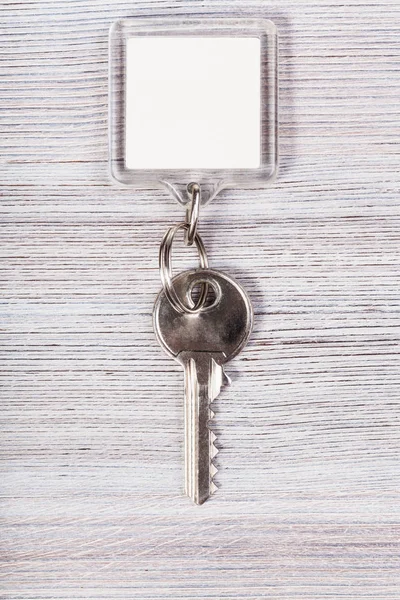 Key with white blank keychain on wood table — Stock Photo, Image