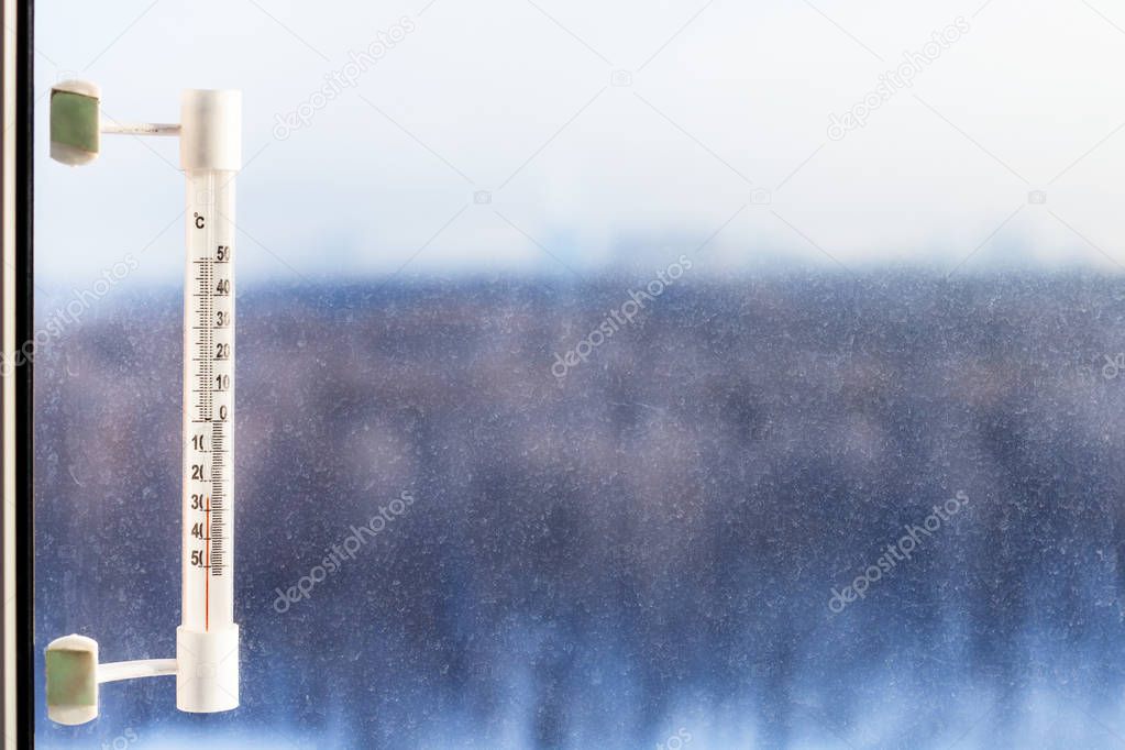 thermometer illuminated by sun in cold winter day