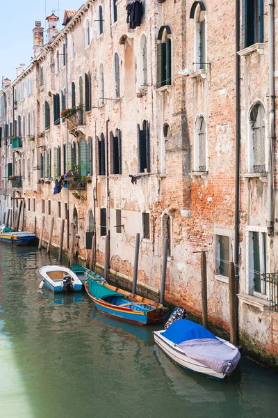Boats near shabby urban house in Venice city Stock Photo