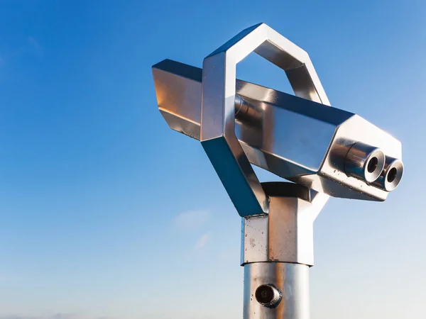 stationary observation binoculars and blue sky