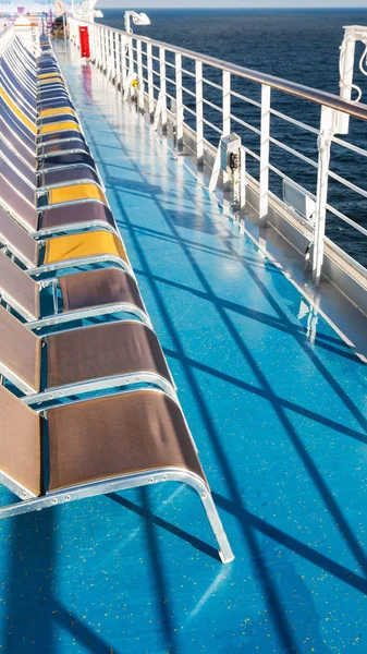 Lijn van lege zonnebaden stoelen op het dek — Stockfoto