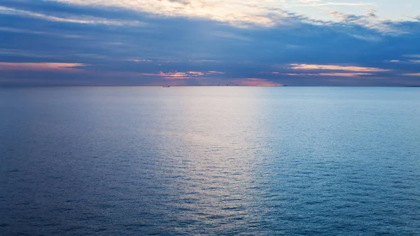 Rosafarbener Sonnenaufgang über der ruhigen blauen Ostsee im Herbst — Stockfoto