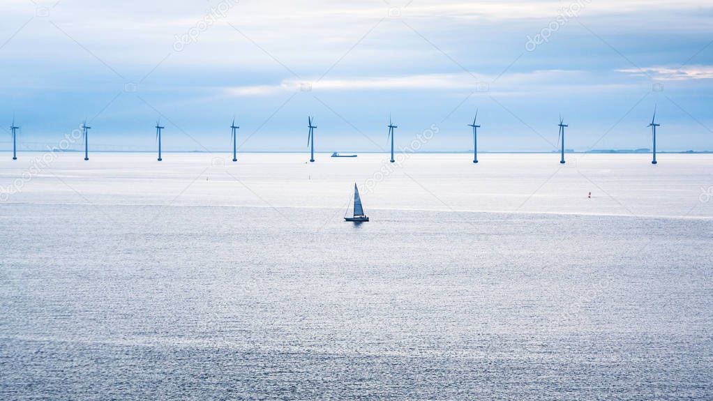 boat and ship near offshore wind farm in morning