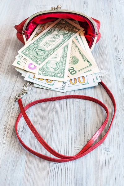 Nás dolary vypadnou z červené kožené kabelky — Stock fotografie
