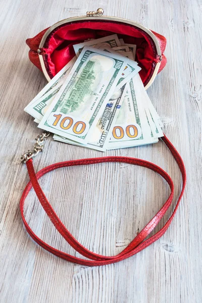 Kırmızı çanta 100 dolarlık banknotlar bozuşmak — Stok fotoğraf